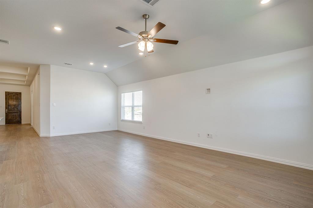 909 Schuberts Road Justin, TX 76247 - Photo 8 of 34 an empty room with wooden floor chandelier fan and windows