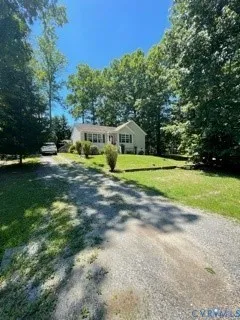 a view of a house with a big yard and large trees