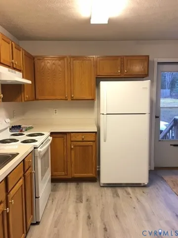 a kitchen with a refrigerator sink stove and cabinets