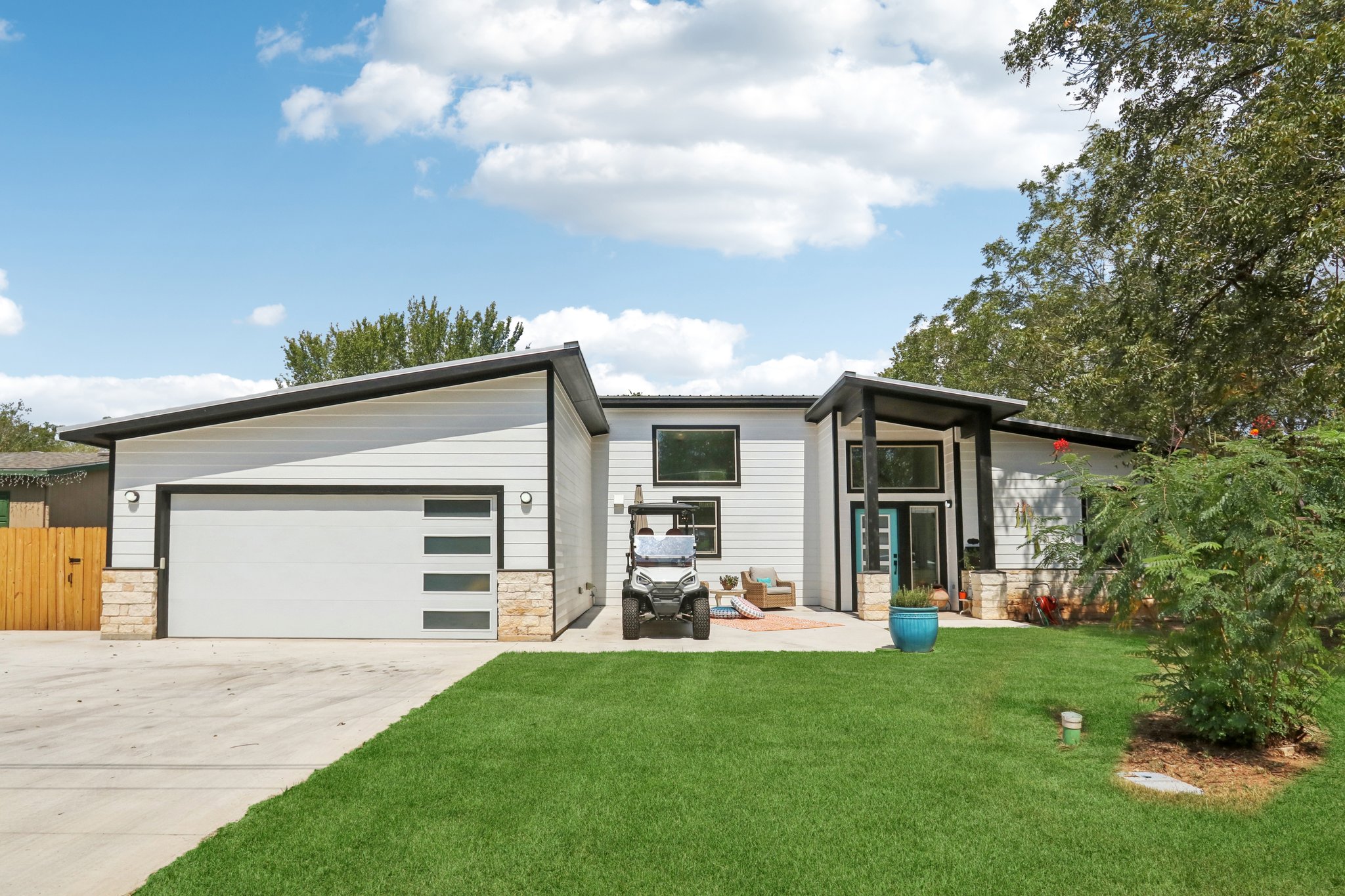 604 Wilhelm Street Bastrop, TX 78602 - Photo 1 of 39 View of front of property featuring stone siding, concrete driveway, and a patio