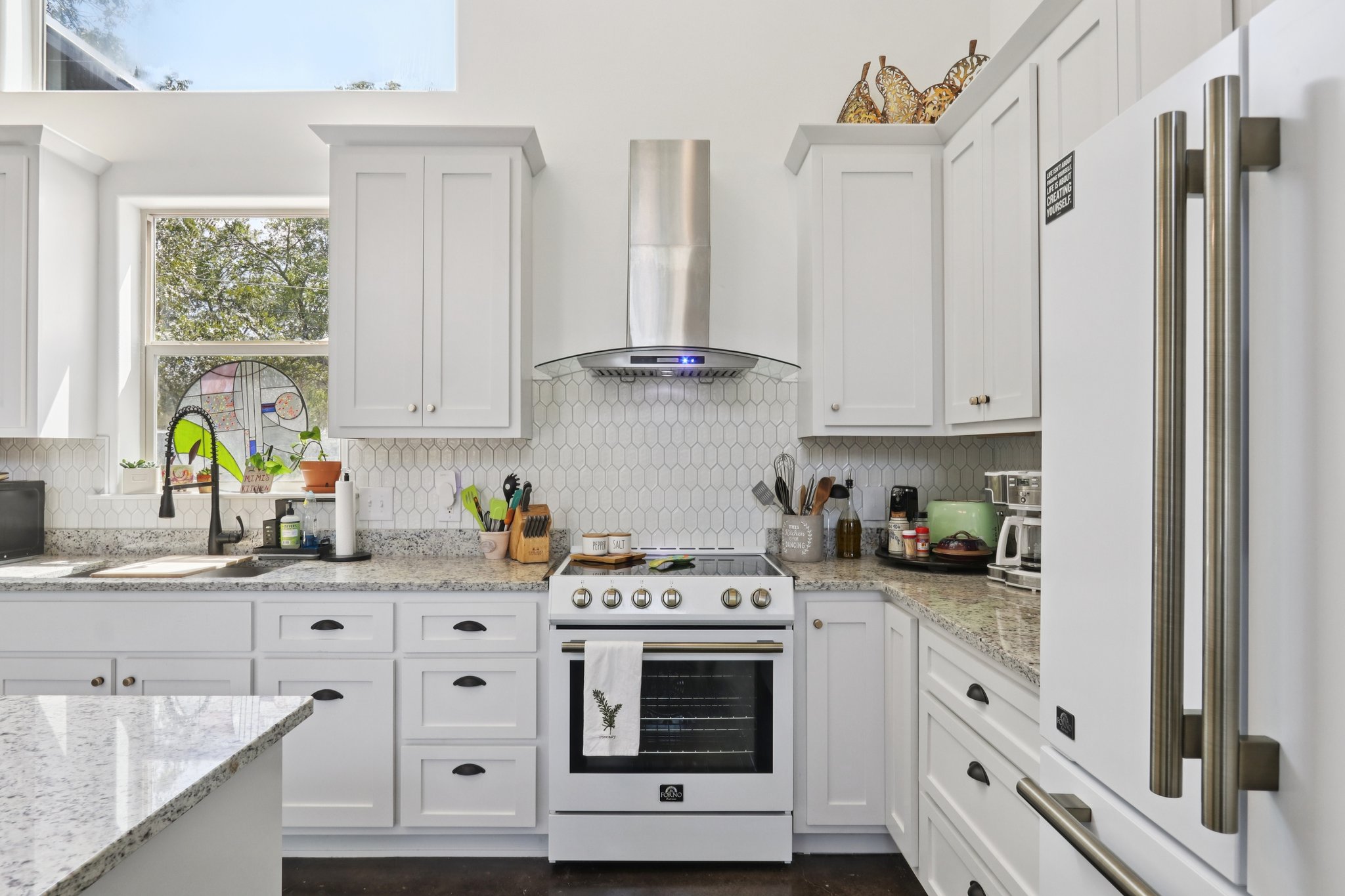 604 Wilhelm Street Bastrop, TX 78602 - Photo 16 of 39 a kitchen with stainless steel appliances white cabinets and a stove top oven