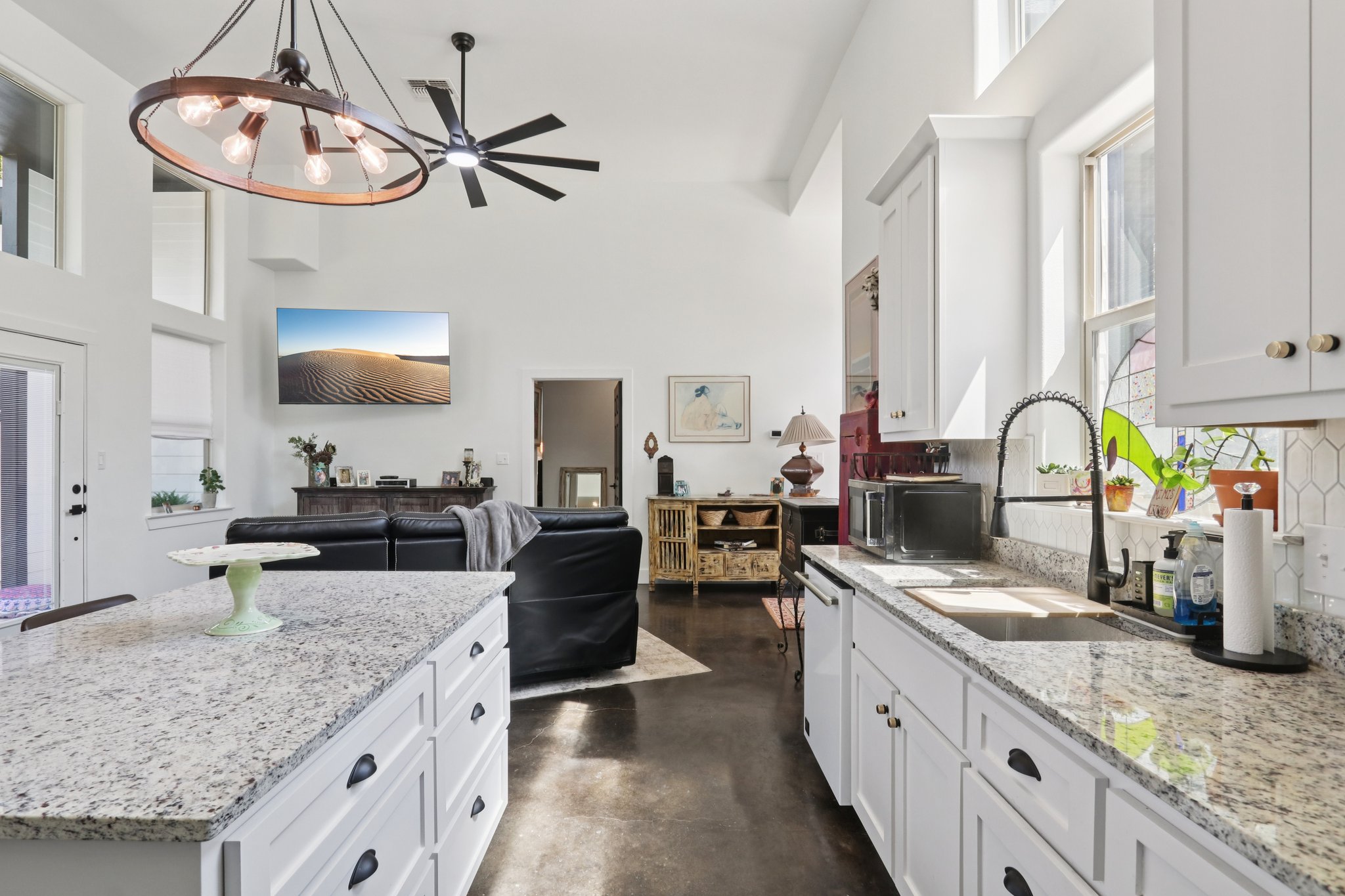 604 Wilhelm Street Bastrop, TX 78602 - Photo 38 of 39 Kitchen with finished concrete flooring, light stone counters, white cabinetry, backsplash, and open floor plan