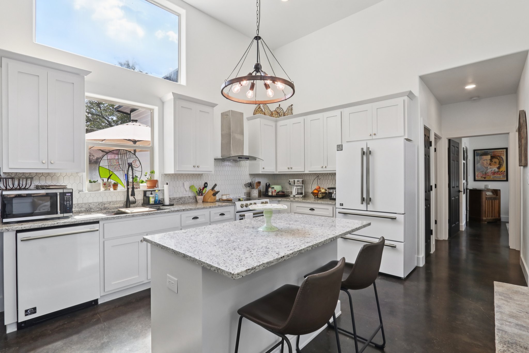 604 Wilhelm Street Bastrop, TX 78602 - Photo 3 of 39 Kitchen featuring white appliances, light stone countertops, a breakfast bar, backsplash, and white cabinetry
