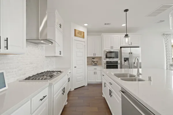 a kitchen with stainless steel appliances granite countertop a sink stove and refrigerator