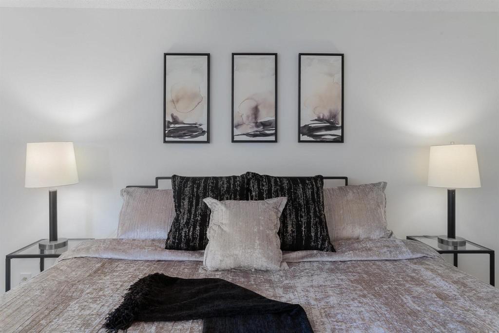 5981 Arapaho Road, Unit 305 Dallas, TX 75248 - Photo 18 of 38 a bedroom with a bed and a lamp