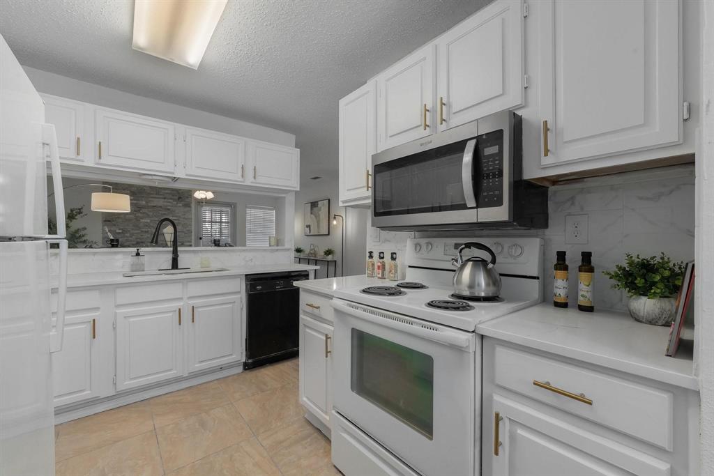 5981 Arapaho Road, Unit 305 Dallas, TX 75248 - Photo 27 of 38 a kitchen with granite countertop a sink stove top oven and microwave