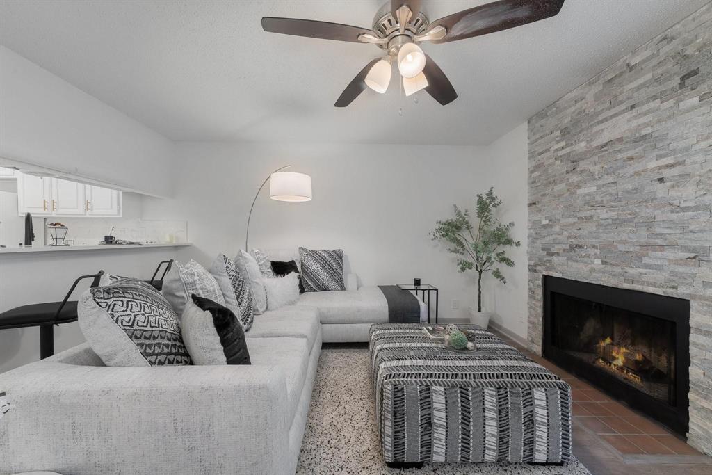 5981 Arapaho Road, Unit 305 Dallas, TX 75248 - Photo 5 of 38 a living room with furniture a fireplace and a chandelier