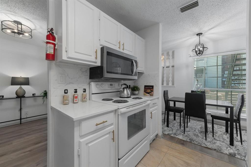 5981 Arapaho Road, Unit 305 Dallas, TX 75248 - Photo 7 of 38 a kitchen with stainless steel appliances a stove a sink a microwave and cabinets