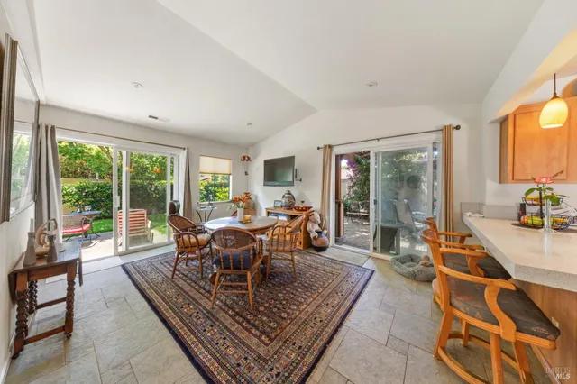 a living room with furniture a rug potted plant and a large window