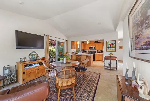a dining room with furniture a flat screen tv and a floor to ceiling window