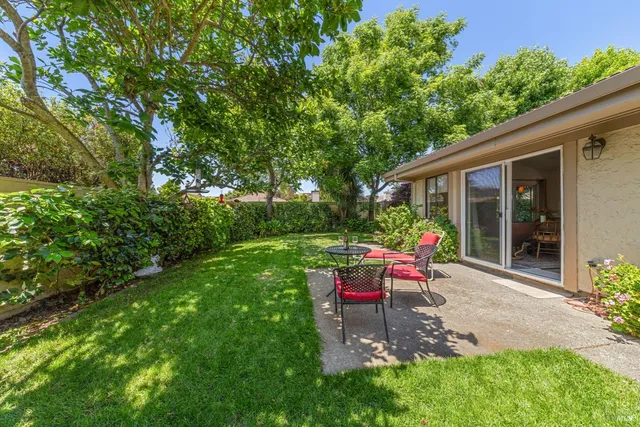 a view of a table and chairs in backyard of the house