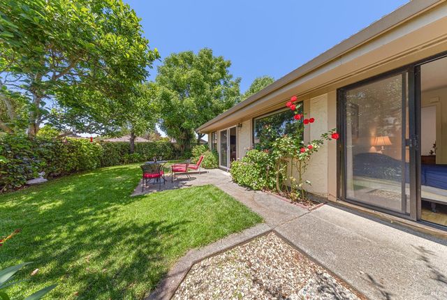 a view of a house with backyard and sitting area