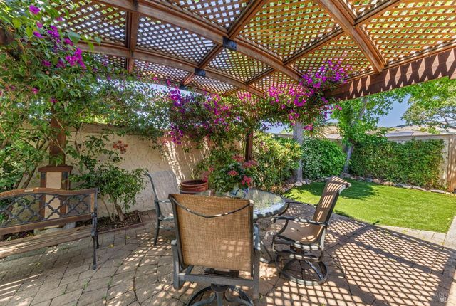 a backyard of a house with a garden and outdoor seating