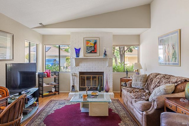 a living room with furniture a flat screen tv and a fireplace