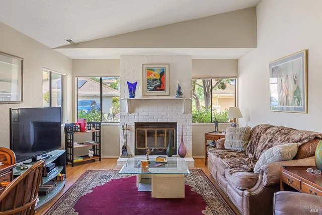 a living room with furniture a flat screen tv and a fireplace
