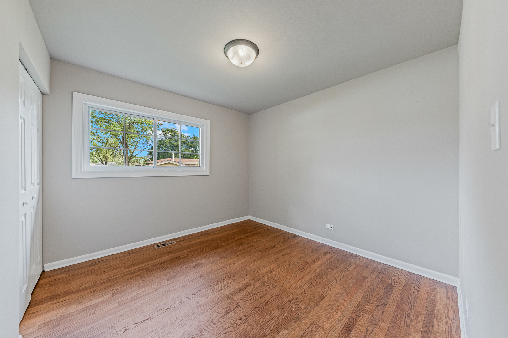 303 Springfield Street Park Forest, IL 60466 - Photo 8 of 16 an empty room with wooden floor and windows