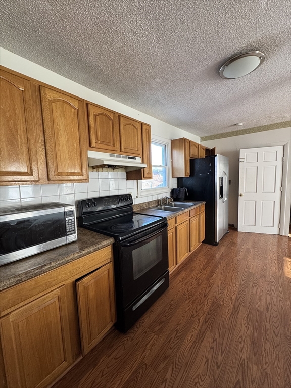 a kitchen with granite countertop a stove top oven and cabinets