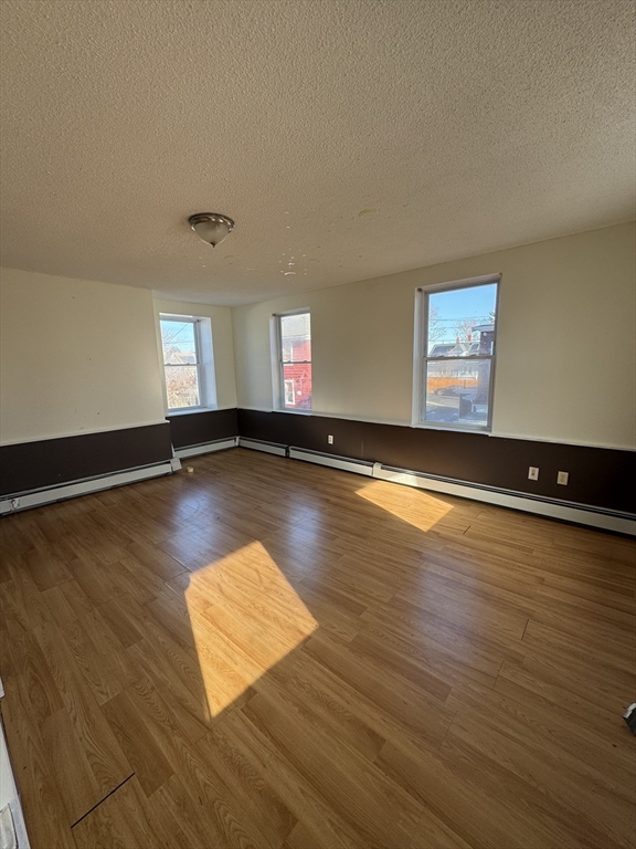 98 Lafayette Park, Unit 2 Lynn, MA 01902 - Photo 8 of 18 an empty room with wooden floor and windows