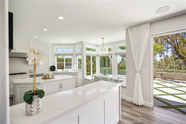 a dining room with wooden floor a chandelier a wooden table and chairs