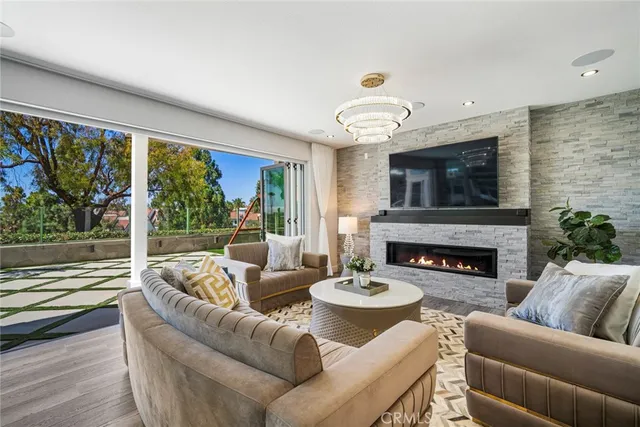 a living room with furniture fireplace and a large window