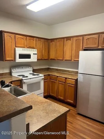 a kitchen with granite countertop a refrigerator stove top oven and sink