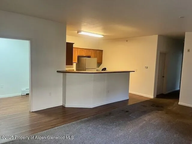 a view of a kitchen with wooden floor and a sink