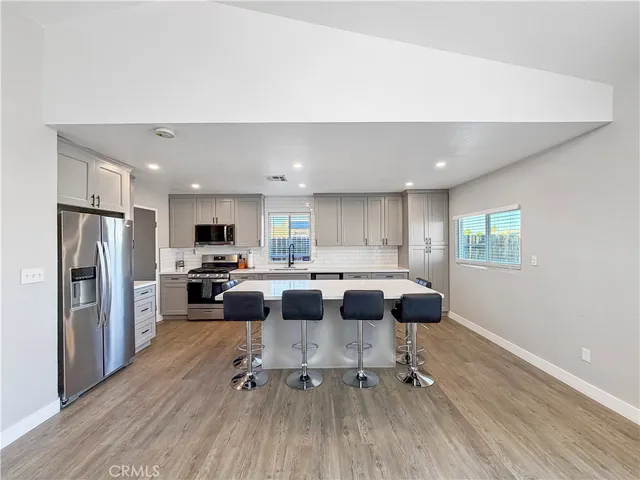 a kitchen with a table chairs refrigerator and microwave