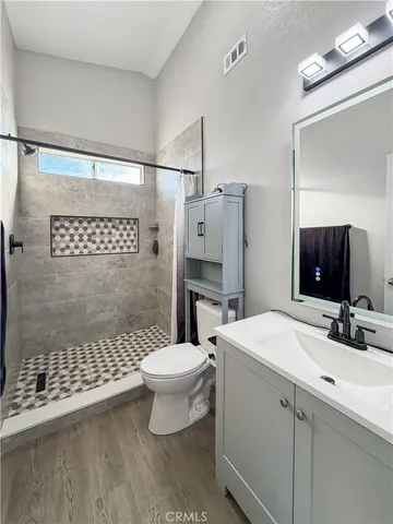 a bathroom with a sink toilet a mirror and shower
