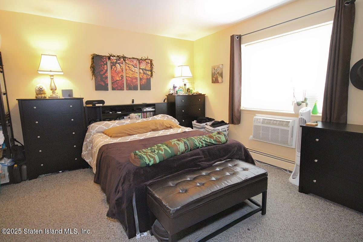 160 Devon Loop, Unit 5 Staten Island, NY 10314 - Photo 11 of 20 a bedroom with a bed and a night stand