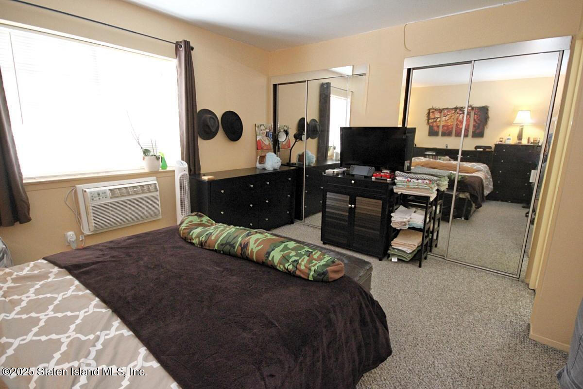 160 Devon Loop, Unit 5 Staten Island, NY 10314 - Photo 12 of 20 a living room with a bed furniture and a flat screen tv