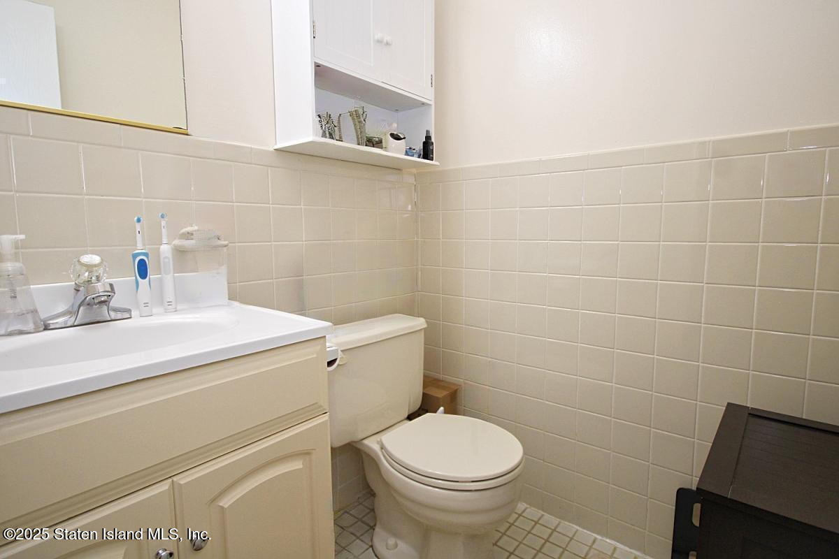 160 Devon Loop, Unit 5 Staten Island, NY 10314 - Photo 13 of 20 a bathroom with a sink a toilet and mirror
