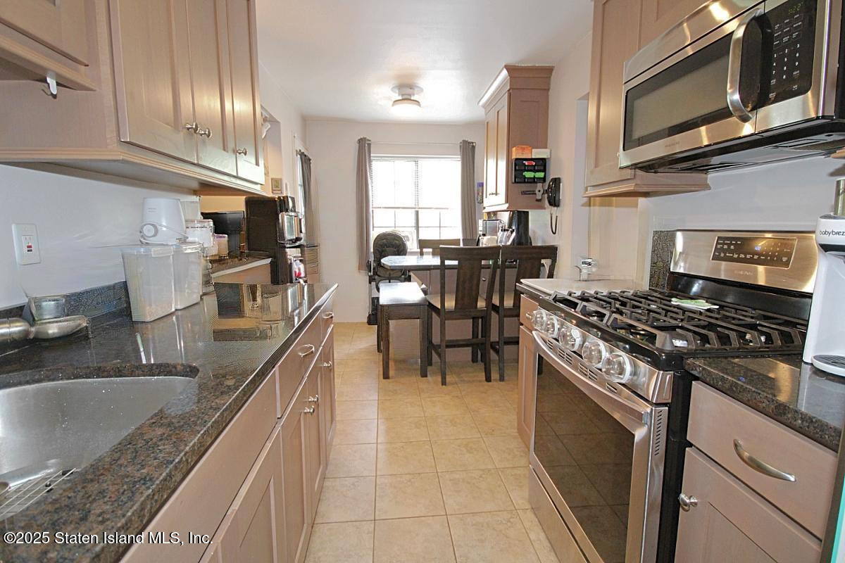160 Devon Loop, Unit 5 Staten Island, NY 10314 - Photo 7 of 20 a kitchen with stainless steel appliances granite countertop a sink stove and cabinets