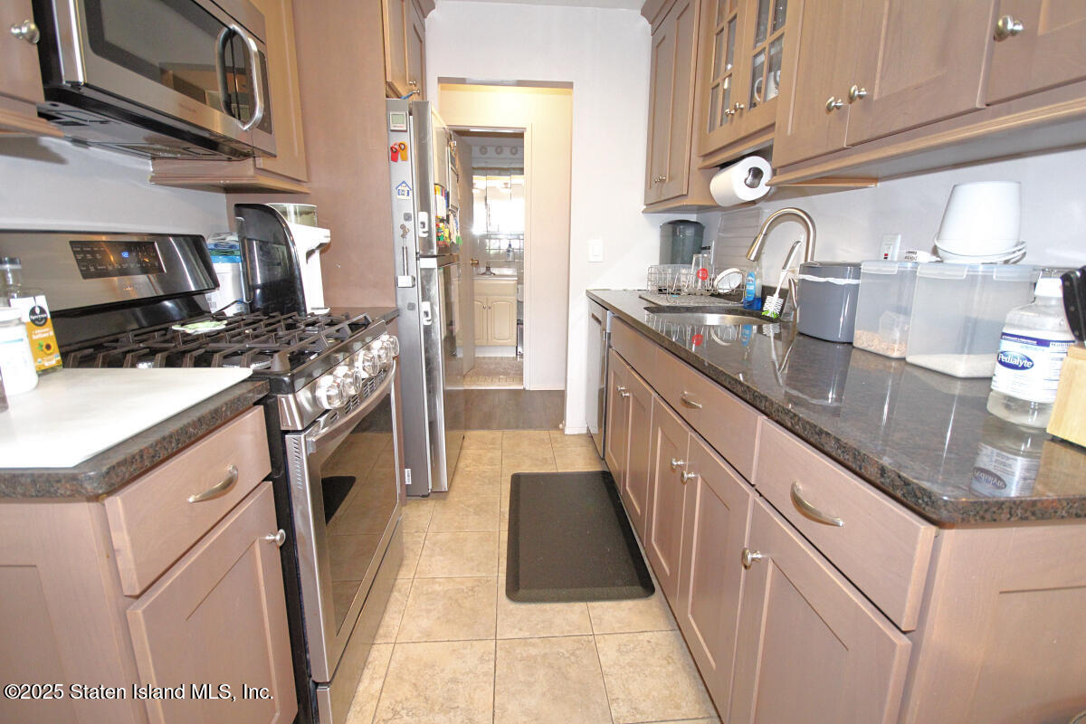 160 Devon Loop, Unit 5 Staten Island, NY 10314 - Photo 8 of 20 a kitchen with stainless steel appliances granite countertop a sink stove and refrigerator