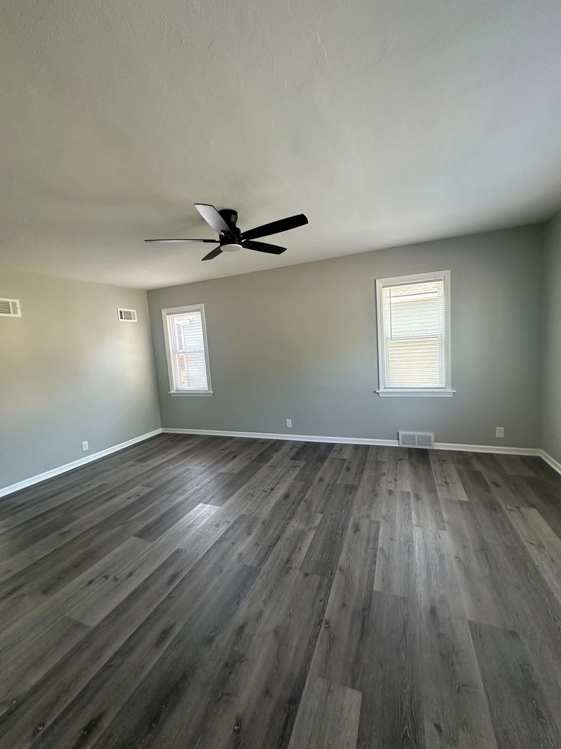 513 Cookane Avenue Elgin, IL 60120 - Photo 7 of 26 an empty room with wooden floor and windows