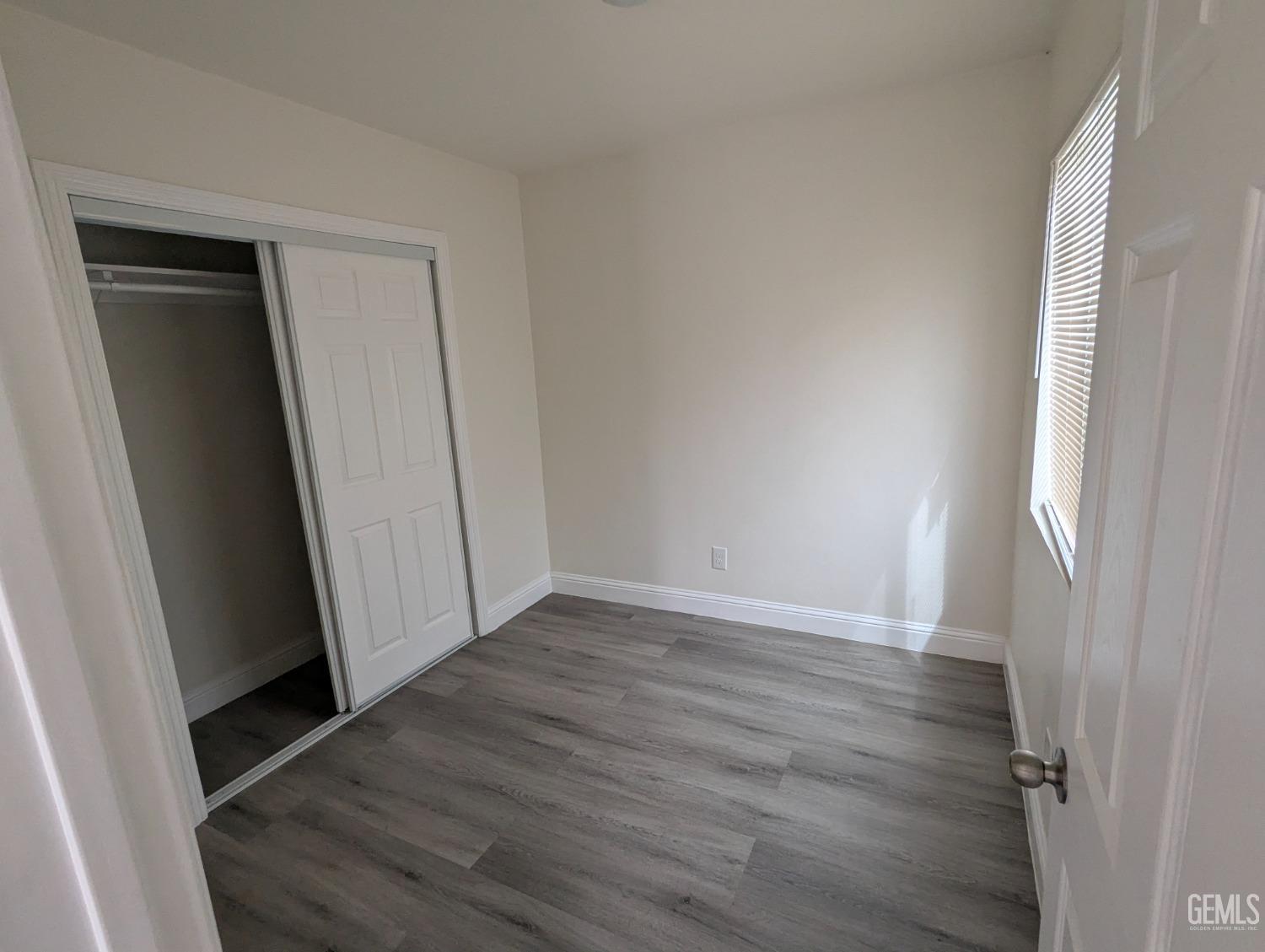 Undisclosed Address Bakersfield, CA 93307 - Photo 16 of 17 an empty room with wooden floor and closet