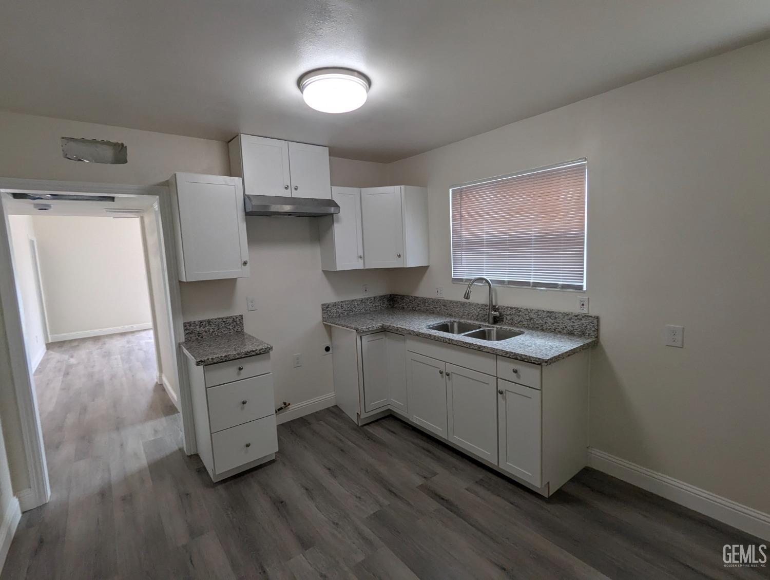 Undisclosed Address Bakersfield, CA 93307 - Photo 7 of 17 a kitchen with stainless steel appliances a sink cabinets and wooden floor