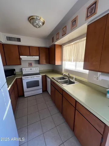 a kitchen with a sink a stove and cabinets