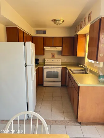 a kitchen with stainless steel appliances granite countertop a refrigerator sink and stove