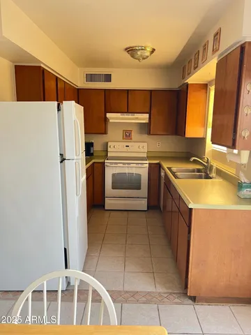 a kitchen with stainless steel appliances granite countertop a refrigerator sink and stove