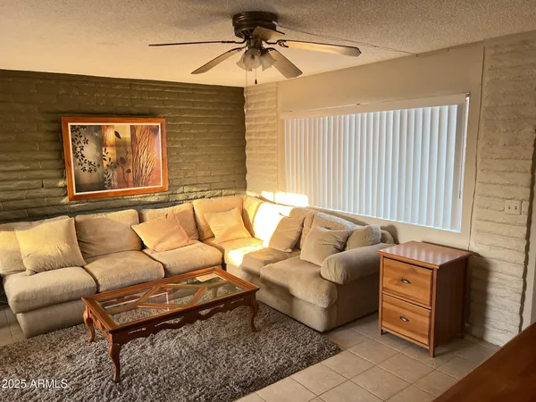 a living room with furniture and a ceiling fan
