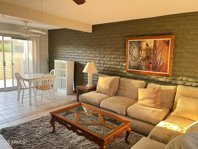 a living room with furniture a rug and a floor to ceiling window