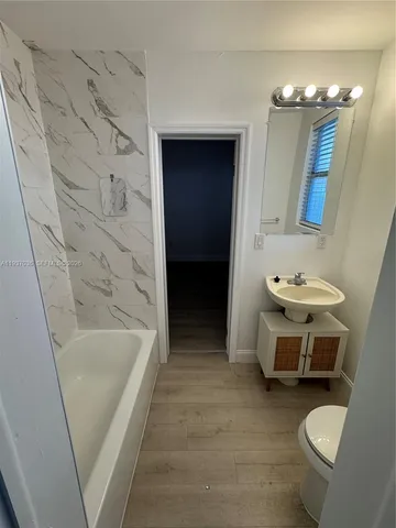 a bathroom with a toilet a sink and mirror
