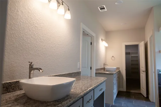 a spacious bathroom with a granite countertop sink and a mirror