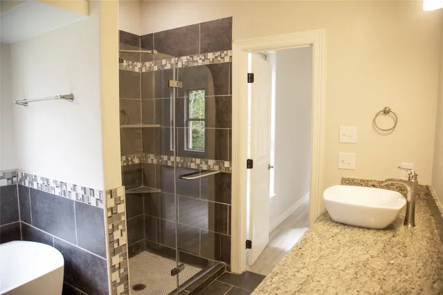 a bathroom with a granite countertop sink and mirror