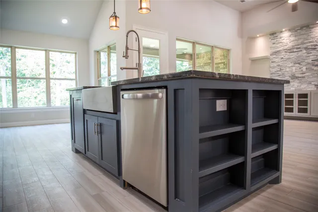 a kitchen with kitchen island a sink wooden floor and a large window