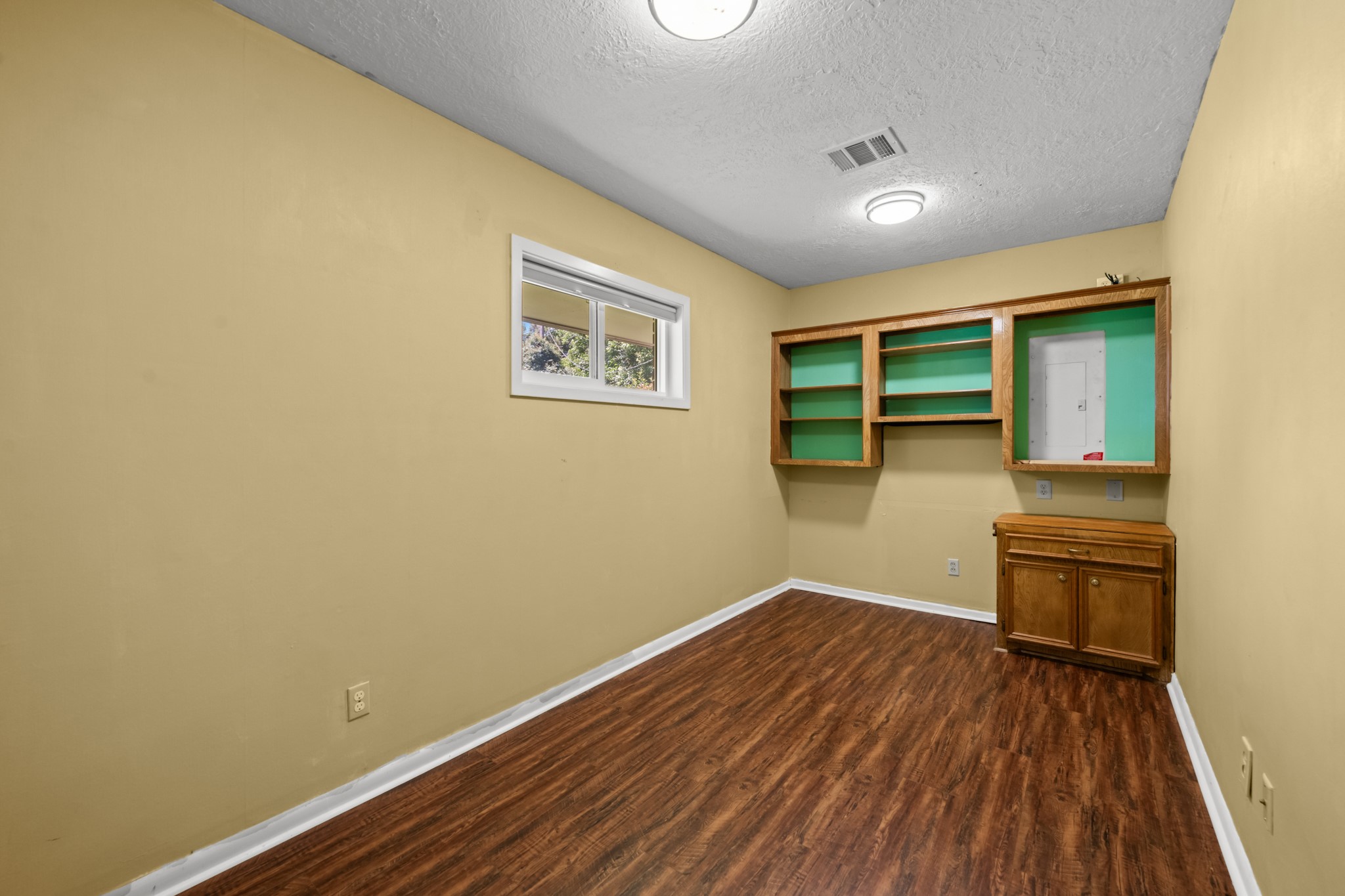 616 Cannan Drive Angleton, TX 77515 - Photo 18 of 49 This dedicated home office features wood-look flooring, built-in shelving and cabinetry, and a functional workspace for remote work, study, or household organization. Natural light from the window creates a comfortable environment while the built-in storage helps keep everything neatly organized.