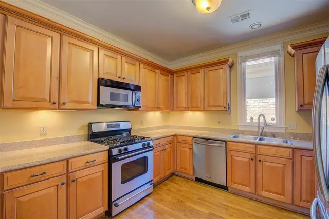 a kitchen with stainless steel appliances granite countertop a sink stove and cabinets