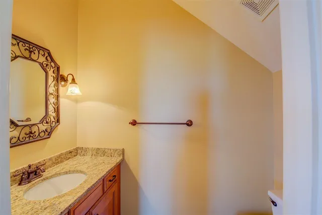 a bathroom with a granite countertop sink and a mirror