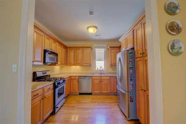a large kitchen with stainless steel appliances granite countertop a stove and a refrigerator
