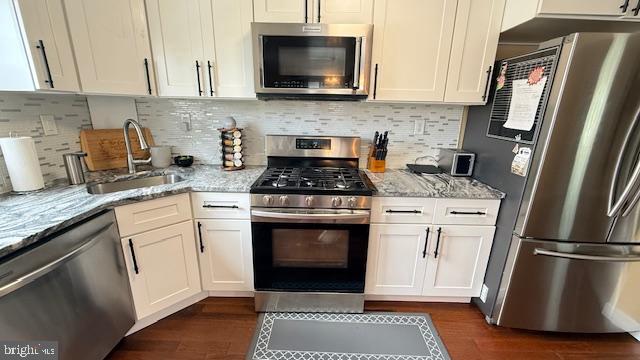 7907 Subet Road Windsor Mill, MD 21244 - Photo 7 of 31 a kitchen with stainless steel appliances white cabinets a stove a sink and a microwave